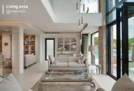 A modern glass cofee table and a white sofa in the middle of the living room.