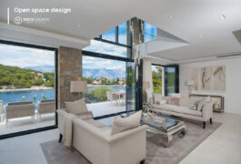 Open space living area with large windows, two white sofas and glass coffee table.