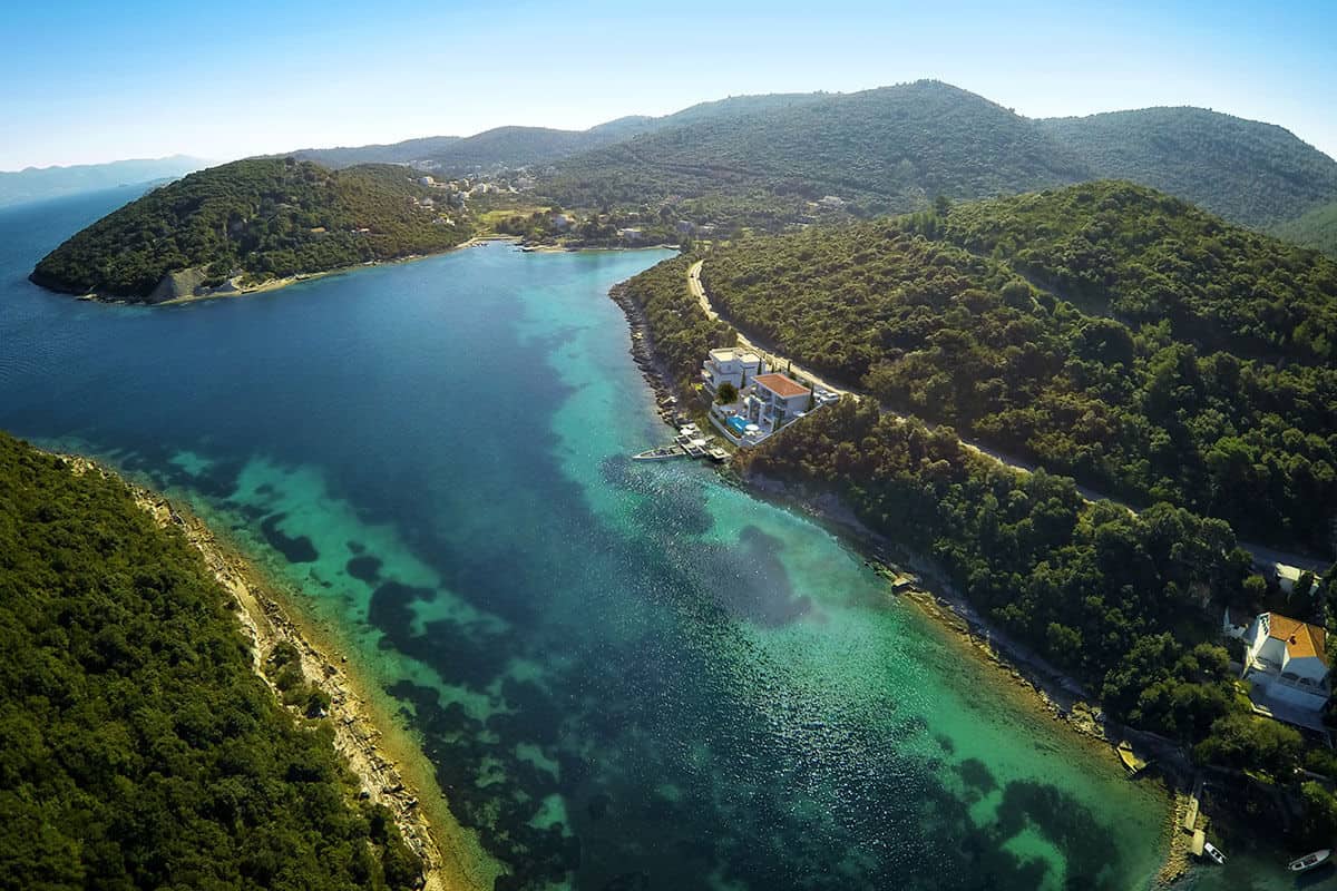 Two seafront villas in the small bay with calm clear blue sea.