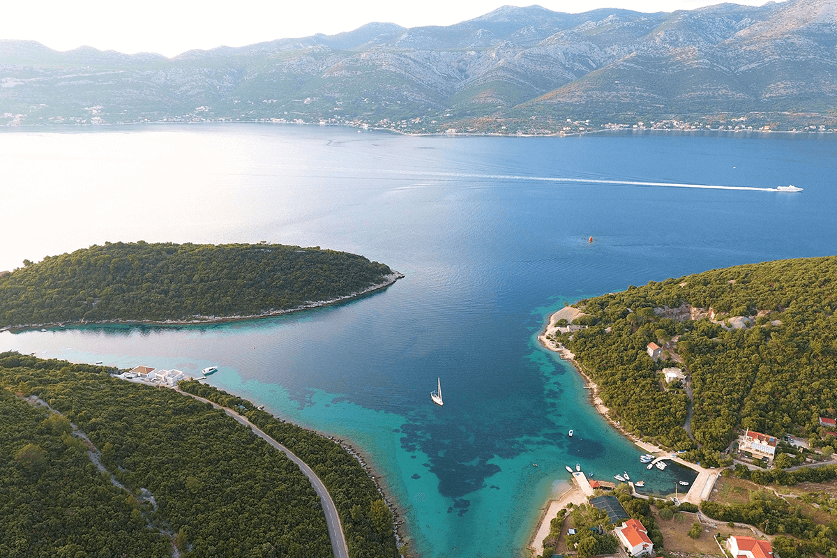 A bay situated between the islands with a blue sea and white yachts.