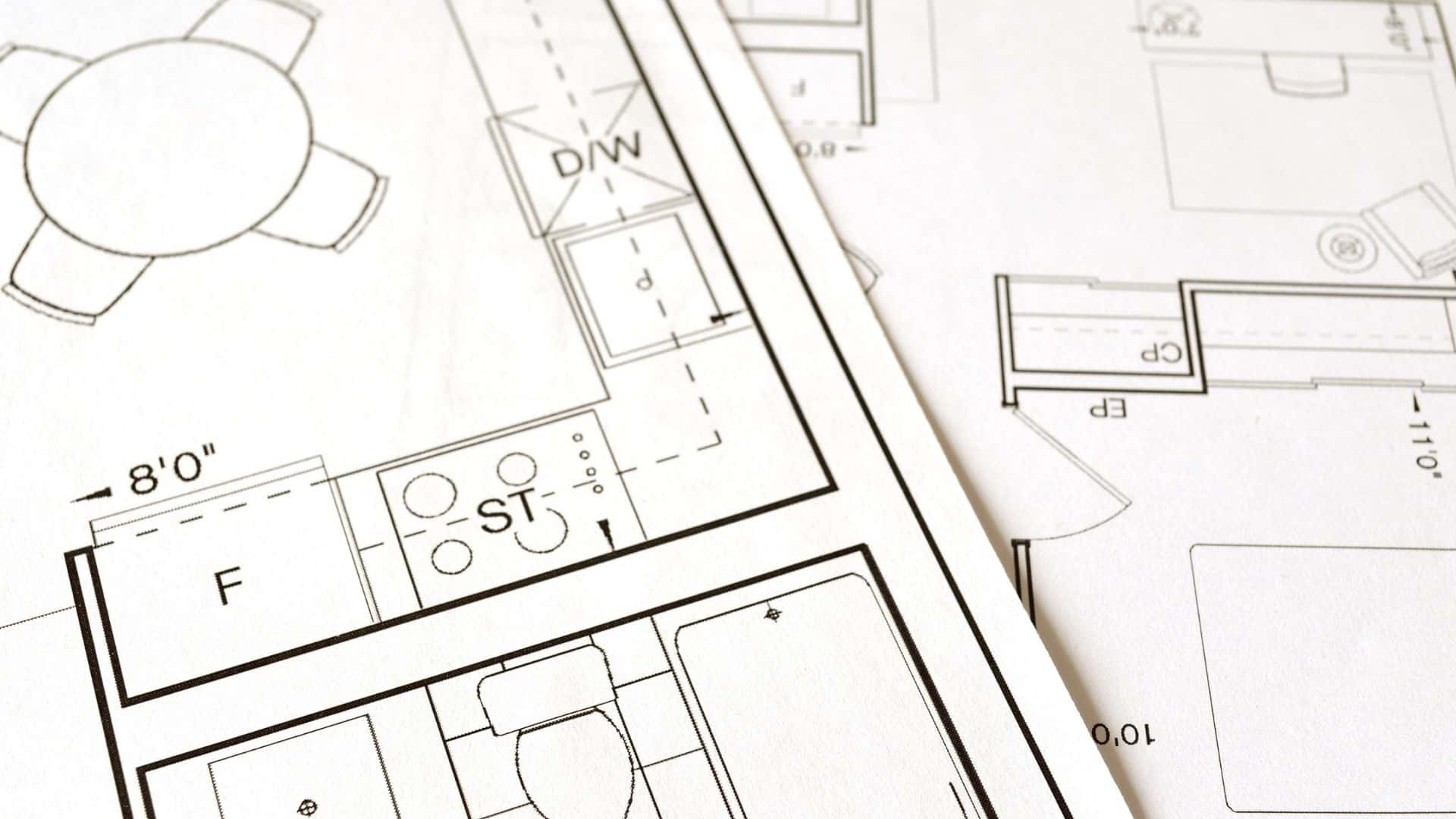 The close-up shot of the architectural plans on the white paper.