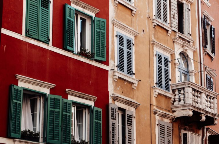 Two houses. The left one is red, while the other one is yellow.