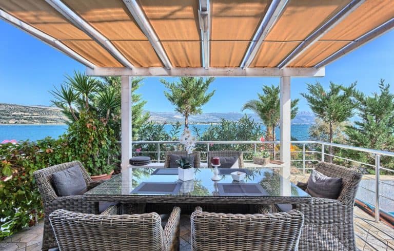The alfresco dining area surrounded by the mediterranean plants like olive tree and palm.