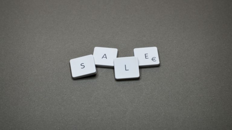 Four keyboard letters on the grey surface forming a word: "sale".