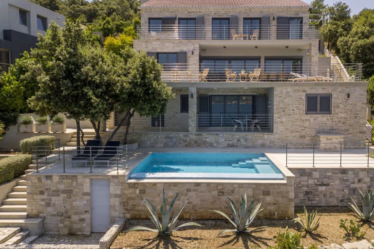 The sea front villa spread over three floors, with a large terrace and the pool in front.