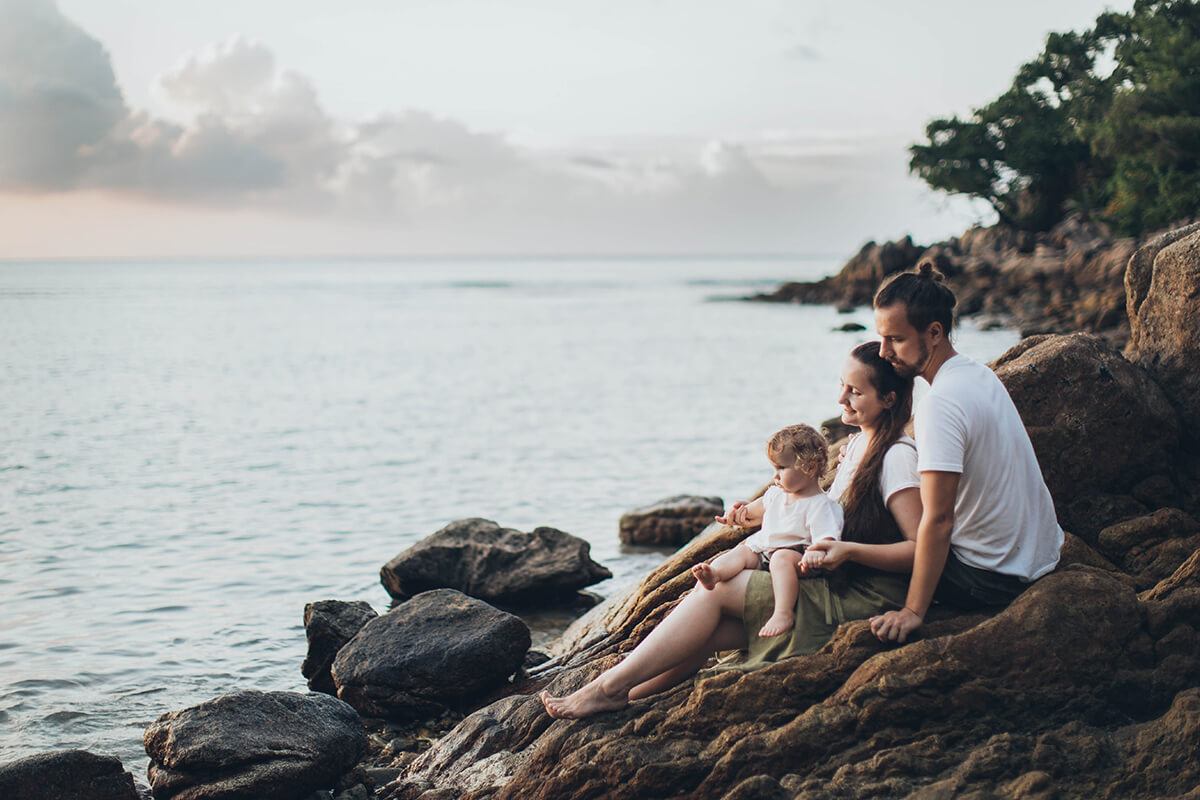A family sitting on the rocks and enjoying the view on the sea.