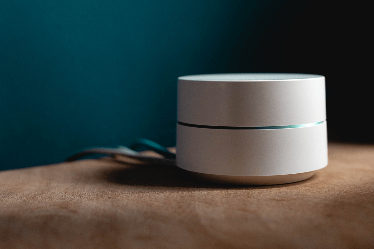 White smart home gadget on wooden table.